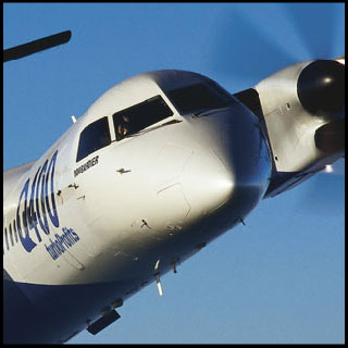 A close up of the front of a flying Bombardier Q400