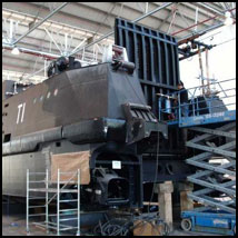 Technician on a gantry carrying out an installation on a large landing craft.