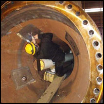 A technician working inside a pipeline section, attaching gauges.
